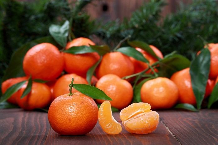 Tangerines with leaves on a wooden table