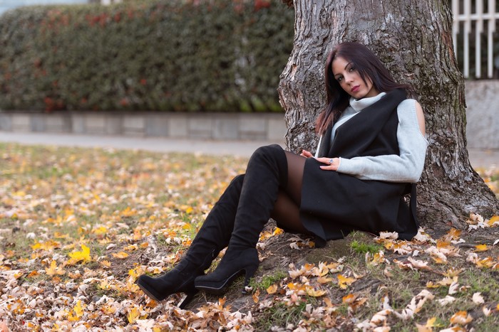 4K Autumn Scene with Woman Sitting by Tree