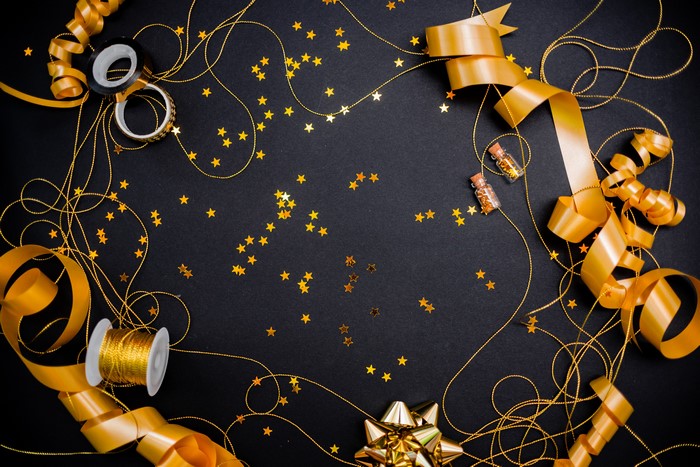 Gold ribbons and star decorations on black background