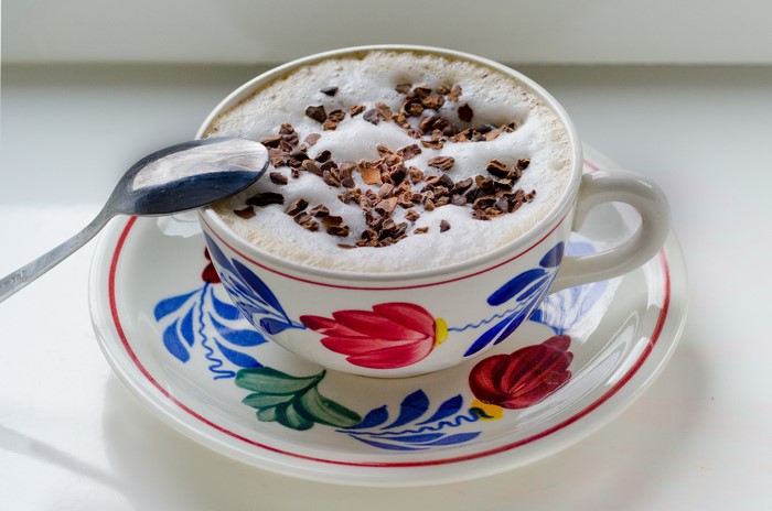 Cappuccino with chocolate shavings and spoon