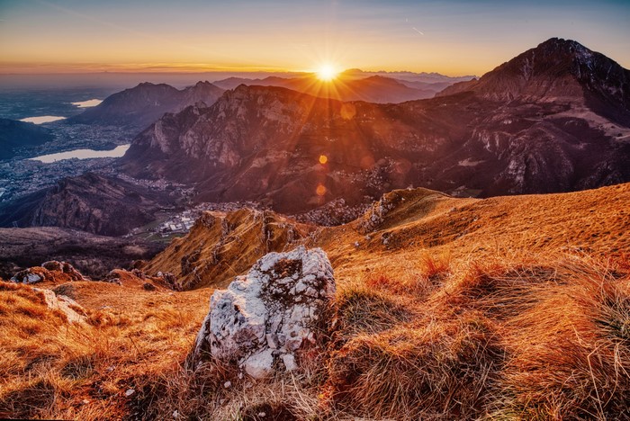 Sunset over mountains and a lake with a town