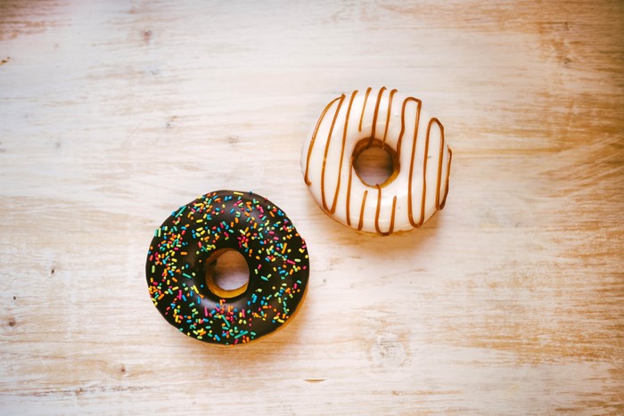 Two donuts on a wooden surface