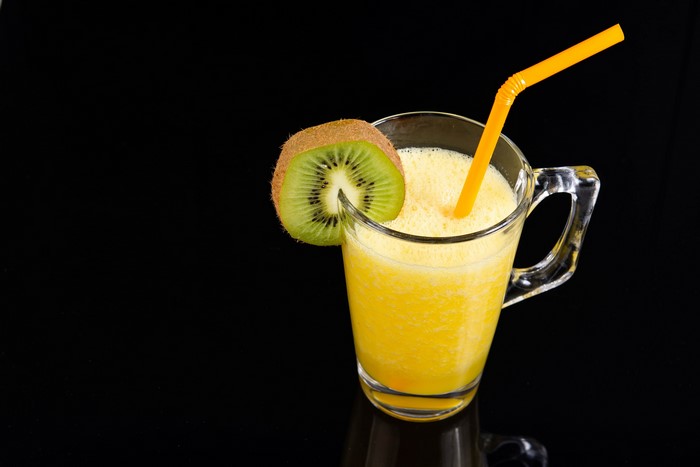 Kiwi smoothie in a mug with a straw