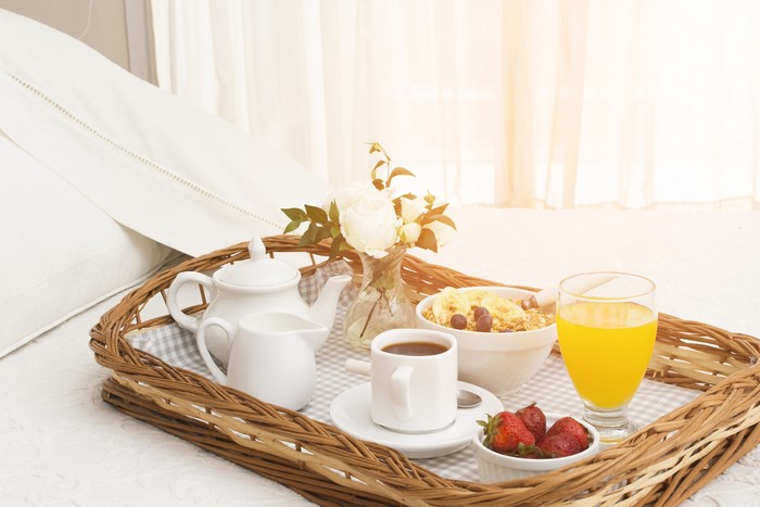 Breakfast tray with juice, coffee, muesli, and strawberries