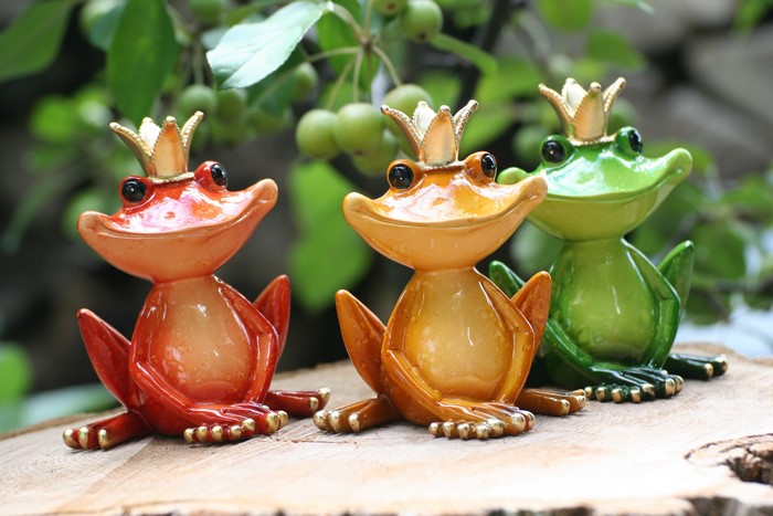 Three frog figurines wearing crowns