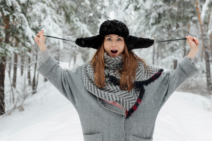 Woman in winter hat and coat in snow