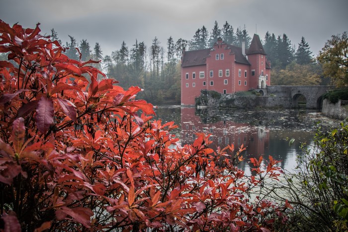 Red castle on a pond in autumn, Czech Republic