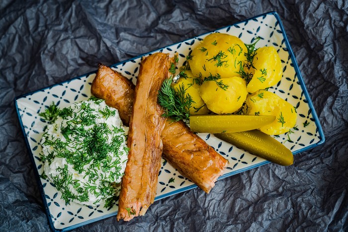Smoked fish with potatoes, sour cream, and pickles