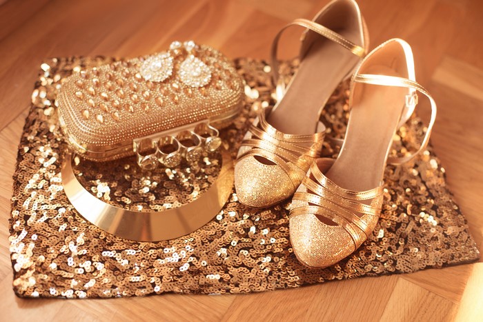 Gold clutch, necklace, and high heels on sequins
