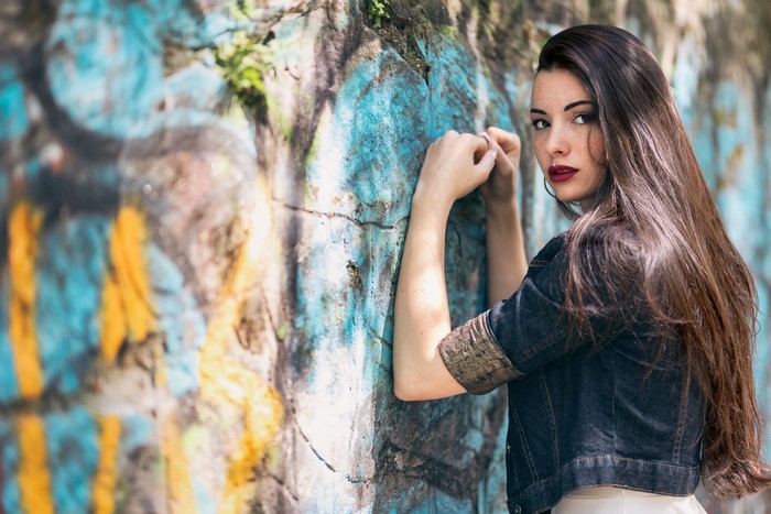 Woman leaning against graffiti wall
