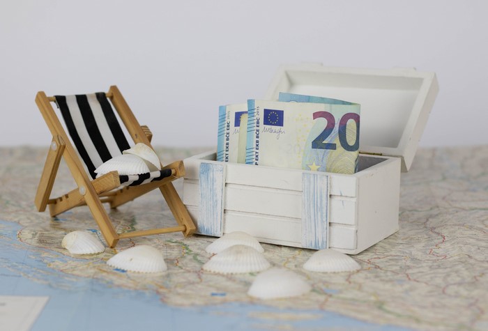 Euro banknotes in a treasure chest with a deck chair and shells
