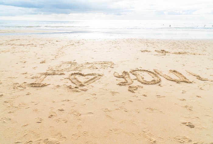 I love you written in the sand on a beach