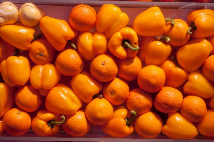Orange fruits and yellow bell peppers