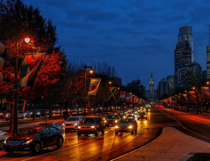 Philadelphia street at dusk with flags and city skyline