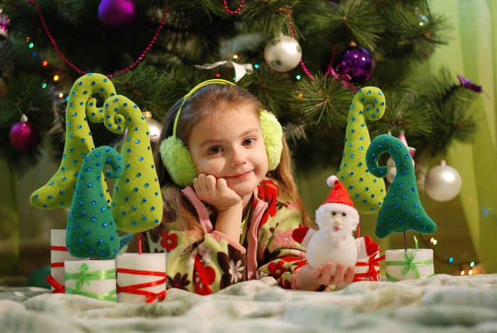 Girl with headphones by Christmas tree with decorations
