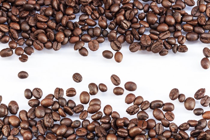 Coffee beans scattered on a white surface
