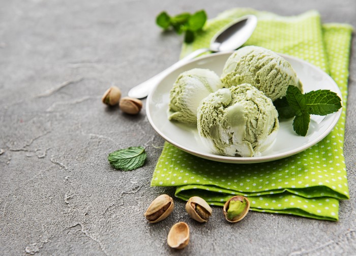 Pistachio ice cream scoops with pistachios and mint