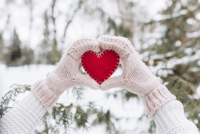 Hands in Mittens Holding a Red Heart in Winter