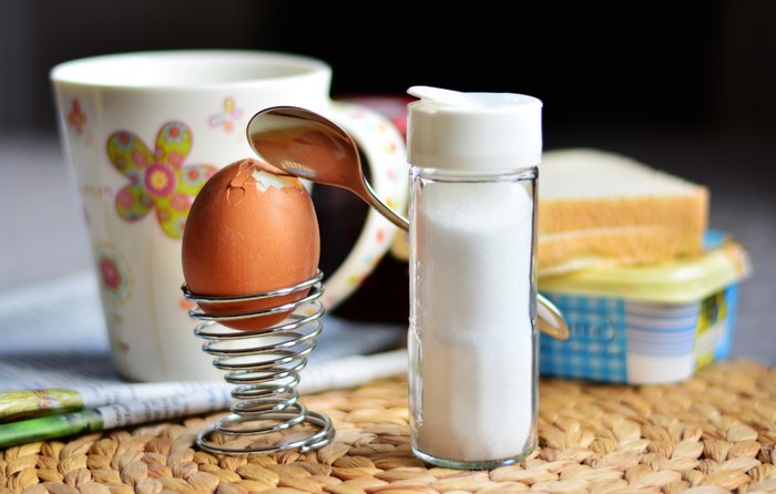 Soft-boiled egg with spoon, salt, and toast for breakfast