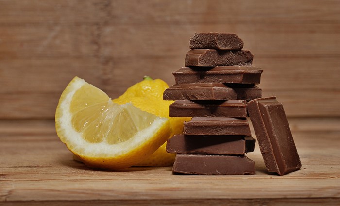 Chocolate pieces and lemons on a wooden surface