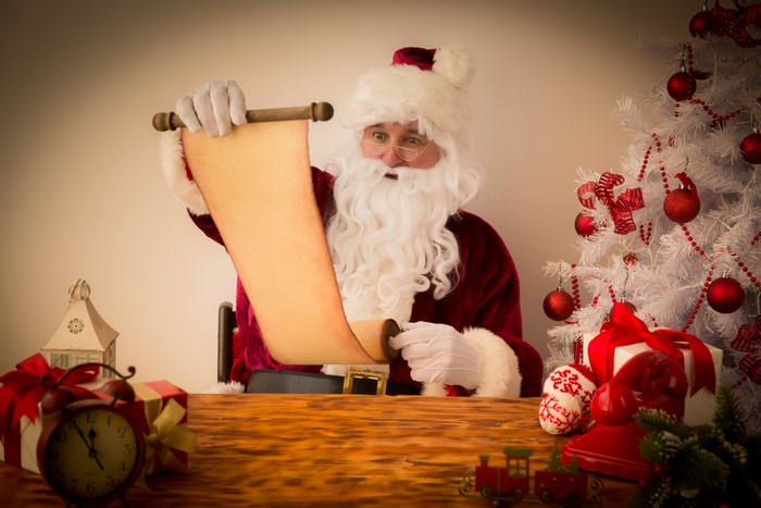 Santa Claus holding a scroll with Christmas decorations