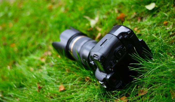 DSLR camera with lens on grass