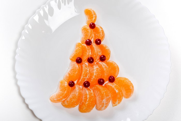Christmas tree made of mandarins and berries on a plate