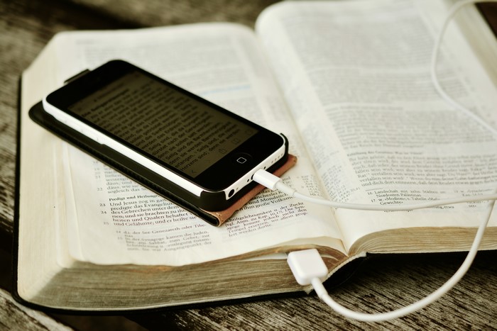 Smartphone charging on an open Bible