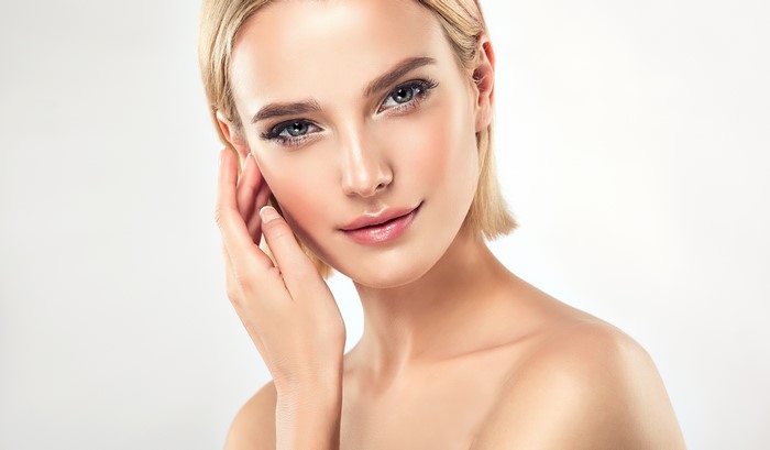 Blonde woman with hand on face