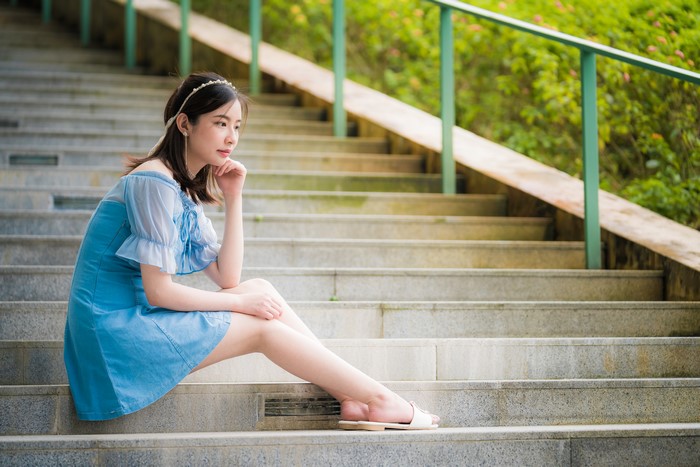 Asian woman sitting on stairs