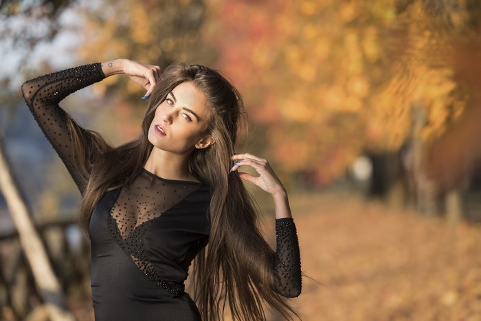 Woman in black dress with hands in hair