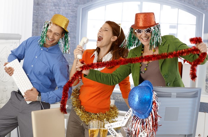 Three people celebrating holidays in an office