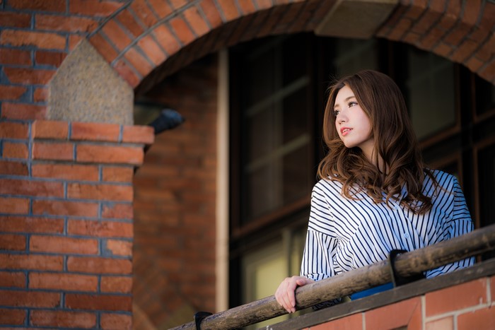 Asian woman with brown hair on a balcony