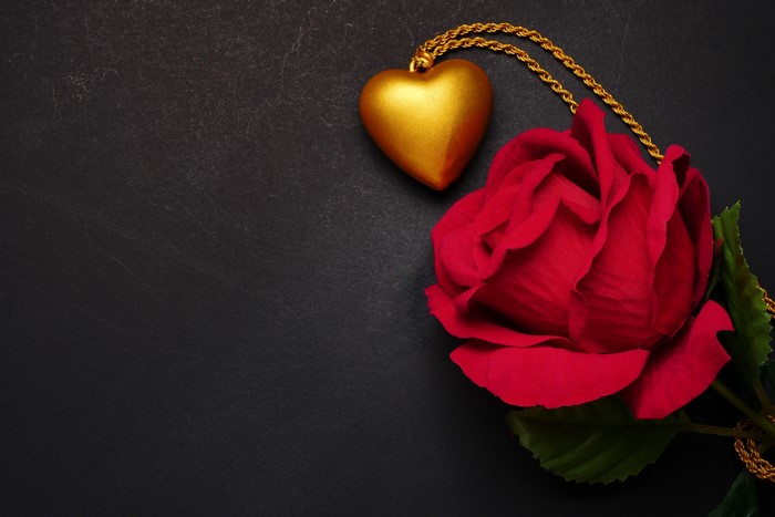 Golden Heart Necklace and Red Rose on Black Background