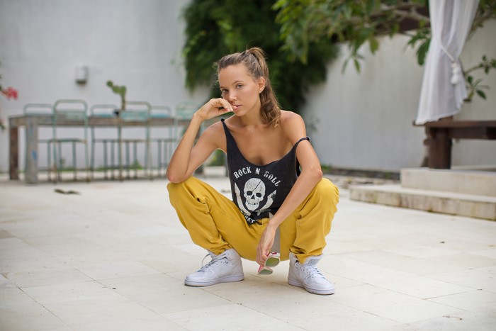 Katya Clover posing in a singlet and yellow pants
