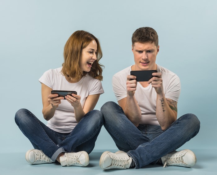Couple playing games on smartphones