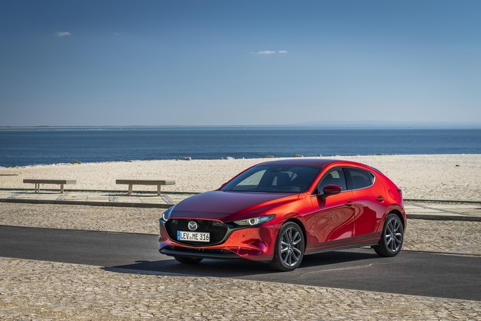 Red 2019 Mazda3 Skyactiv-G Hatchback by the sea