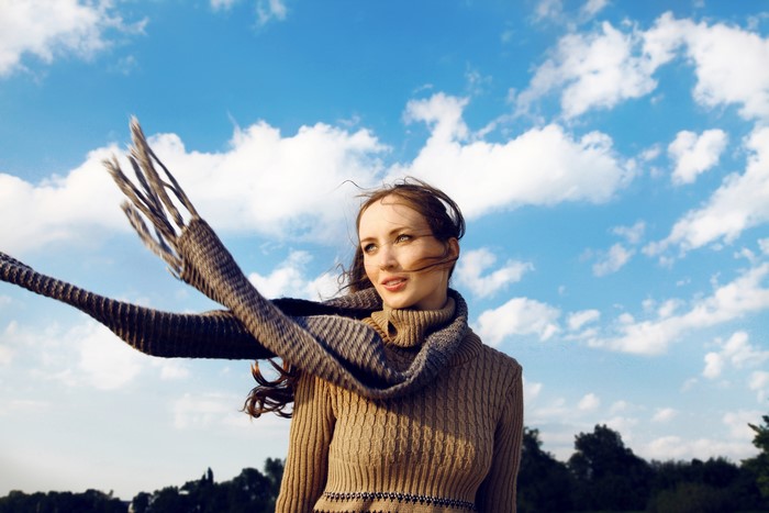 Woman with scarf in the wind under blue sky