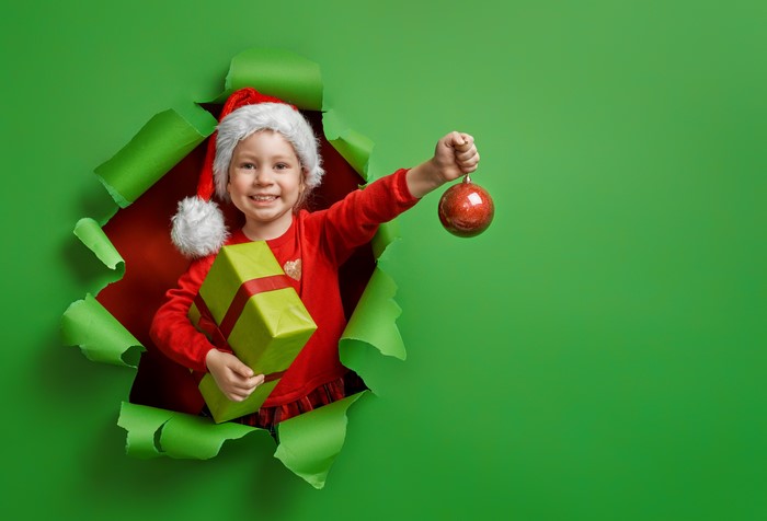 Girl in Santa hat with Christmas gifts and ornament