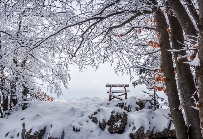 Snow covered bench on a mountain top