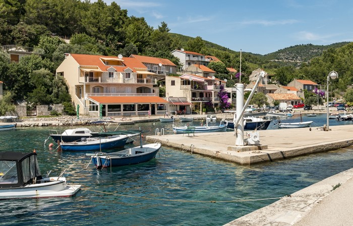 Boats docked in a bay with houses in Croatia