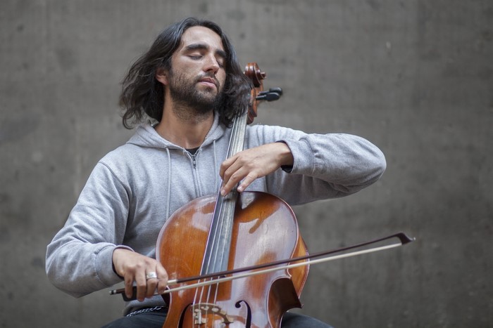 Man playing cello with eyes closed