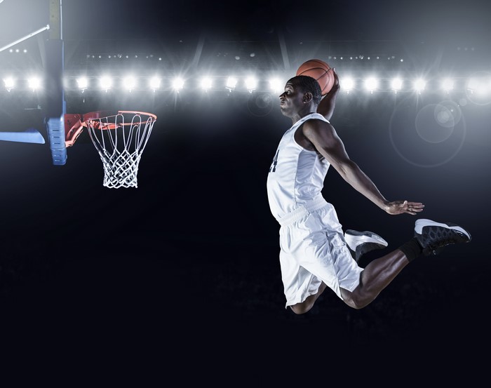 Basketball player dunking in a stadium