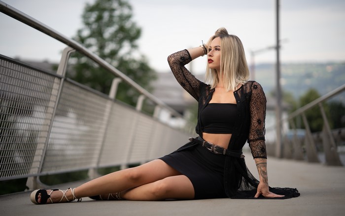 Woman in black sitting on a bridge