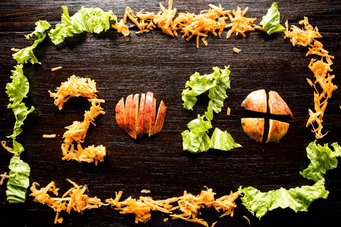 2020 arranged with shredded carrots and apples on wood