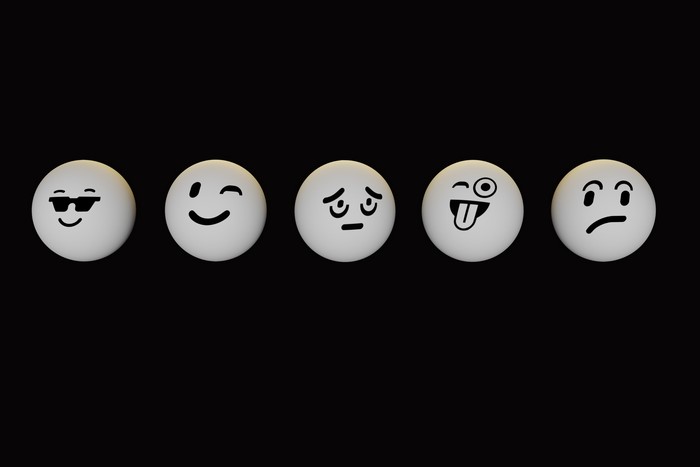 Five emoji faces on a black background
