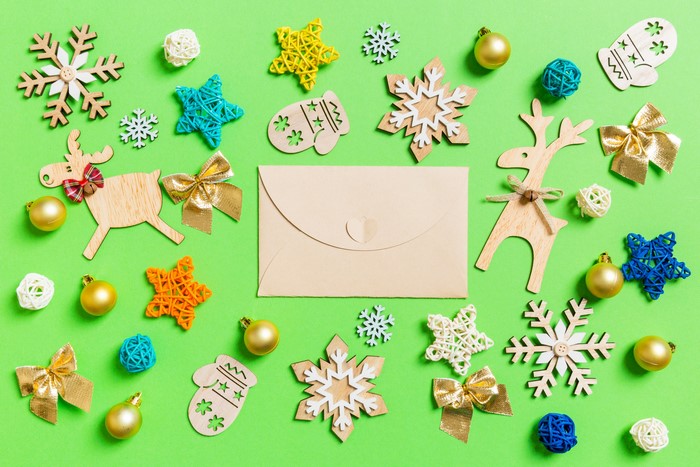 Christmas decorations and envelope on green background