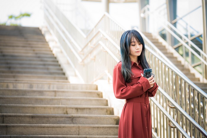Asian Woman in Red Dress with Phone on Stairs 4K