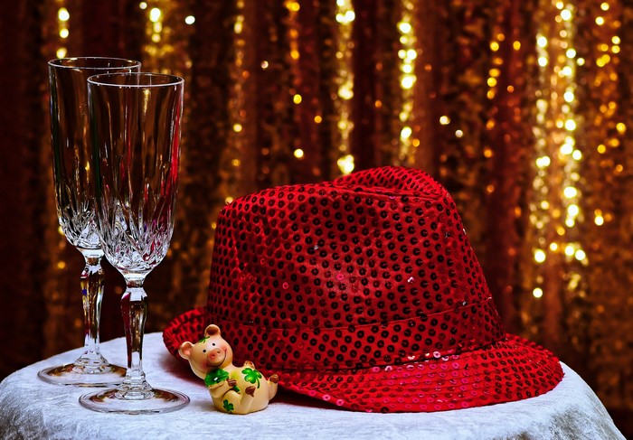 Red sequined hat and champagne glasses with pig figurine