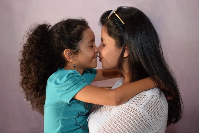 Mother and daughter kissing